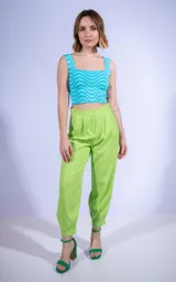 Pantalón sastrero color verde manzana, de corte tipo babucha con pinzas en la cintura y terminación en puño. Cuenta con cierre frontal y botón a tono.