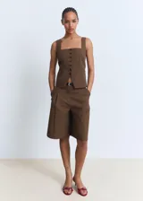 Short marrón de corte recto y largo bermuda, con diseño de pinzas en la parte delantera, bolsillos laterales y cierre frontal oculto.