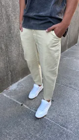 Pantalón tipo jeans de corte slouchy en color arena, con diseño de tiro medio, bolsillos laterales y ajuste cónico en los tobillos.