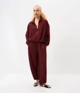 Pantalón balloon de modal color bordó, de corte amplio en las piernas con botamangas ajustadas, cintura con cordón ajustable y bolsillos funcionales.