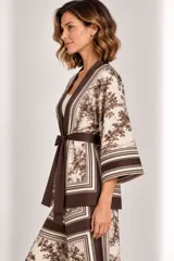 Kimono de seda liviano con estampa estilo toile de Jouy en tonos marrones y beige, con detalles de guardas geométricas, mangas tres cuartos anchas, bolsillos laterales y lazo para ajustar en la cintura.