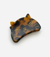 Pinza para el pelo con diseño de cara de gato, realizada en acetato con acabado marmolado en tonos marrones y detalles grabados en metal dorado.