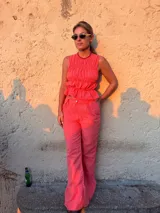 Pantalón largo de tiro alto con estampado a cuadros vichy en tonos rojo y blanco, de corte recto y holgado.