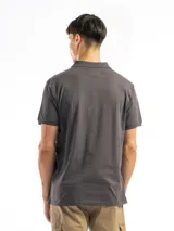 Remera tipo polo de manga corta, color blanco liso, con cuello de polo y tapeta de dos botones.