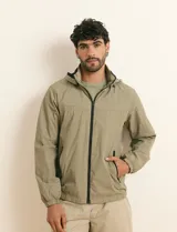 Campera impermeable gris con capucha, cierre frontal y bolsillos laterales con cremallera.
