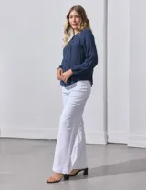 Blusa azul marino de Zac & Rachel con cuello a la base, abertura central con botones y detalle de broderie en el frente. Tiene mangas largas con terminación elastizada.