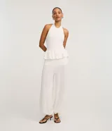 Pantalón aladín blanco de corte ancho y voluminoso, confeccionado en piquet texturizado con cintura elástica y puños ajustados en los tobillos.
