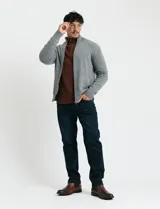 Cardigan de punto gris con cuello alto, cierre frontal de metal con doble cursor y bolsillos laterales. Presenta puños y cuello en tejido canalé.