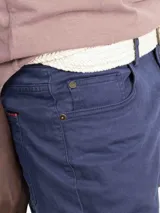 Pantalón de hombre de corte chino, color azul marino, con cinco bolsillos y ruedo doblado.