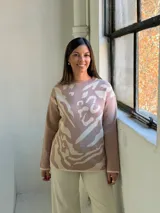 Sweater de tejido de punto con diseño abstracto en tonos beige y crema, de corte holgado, cuello redondo y manga larga.