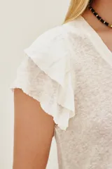 Remera blanca de lino, corte ajustado, cuello redondo y mangas cortas con volados.