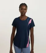 Remera deportiva de manga corta color azul marino con diseño de ondas y detalles estampados en tonos rosados y celestes. Confeccionada en microfibra de poliéster y elastano, de secado rápido y corte entallado.