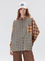 Camisa de viscosa con estampado de rombos en tonos tierra, azul y rojo. Presenta cuello clásico, cierre frontal con botones, bolsillo delantero cuadrado y logo bordado. De corte holgado y manga larga.