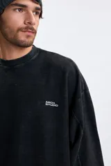 Sudadera de cuello redondo con efecto lavado, color gris oscuro, con estampa tipográfica blanca en la espalda.