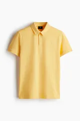 Remera polo de manga corta en punto de algodón liviano, color amarillo claro, con cuello y tapeta de botones. Presenta un corte ajustado al cuerpo.