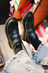 Bota corta de cuero negro con suela track y cierre mediante tiras con velcro en el empeine.