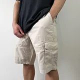Bermuda cargo de gabardina color beige, con bolsillos laterales con solapa y bolsillos delanteros, de corte holgado.