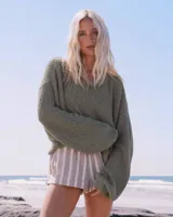 Sweater Billabong Open Air de tejido de punto rústico, color verde militar, con escote en V pronunciado y mangas largas holgadas de caída relajada.