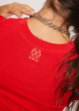 Remera roja de tela stretch suave con leve brillo y mangas cortas. Tiene el isotipo de la marca bordado en la espalda.