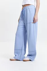 Pantalón de felpa negro con cintura elastizada ajustable, bolsillos laterales y corte acampanado.