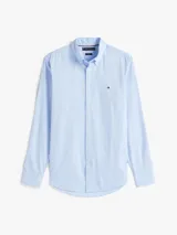 Camisa de algodón elástico con tejido dobby, color celeste claro, de corte slim, cuello con botones y puños redondeados con botón. Presenta el logo de Tommy Hilfiger bordado en el pecho.