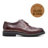 Zapato de vestir acordonado color marrón oscuro, con detalles de perforaciones y suela negra. Fabricado en cuero.