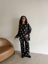 Pantalon de lanilla con estampado de lunares blancos sobre fondo negro, de corte recto y holgado con cintura elástica.