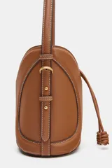 Bolso bandolera formato saca color tostado, con detalle de pespuntes decorativos en el cuerpo, cierre mediante fruncido con cordones y compartimento interior en tejido.