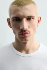 Camiseta de algodón gris jaspeado, de corte regular, con cuello redondo y manga corta.