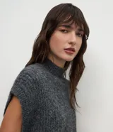 Chaleco de punto gris oscuro con textura jaspeada, diseño sin mangas, corte holgado y cuello alto tipo mock neck.