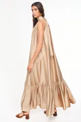 Vestido largo de viscosa color bordó, con cuello halter alto, corte holgado y volante fruncido en el bajo.