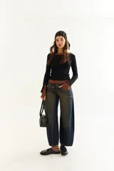 Top de manga larga con diseño de doble capa superpuesta, combinando una capa superior negra y una inferior marrón. Presenta cuello redondo, ajuste al cuerpo y detalle de bordado BG en la parte inferior.