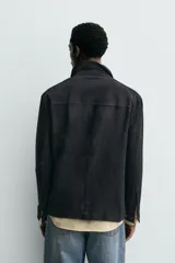 Sobrecamisa de ante color negro, con corte relaxed fit, cuello solapa, manga larga con puño abotonado, bolsillos de plastrón en la cadera y cierre frontal con botones.
