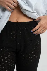 Pantalón negro de tejido calado con cintura elástica.