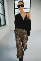 Pantalón bombacho de tiro medio con estampado animal print, bolsillos delanteros, bajo con puño y cierre frontal con cremallera y gancho metálico.