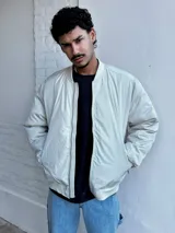 Campera bomber color crudo de nylon con cierre frontal y bolsillos laterales.