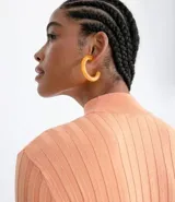 Polera color camel de punto acanalado, con cuello alto y mangas largas.