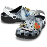 Zuecos tipo Crocs de diseño slip-on, con estampado fotográfico en blanco y negro de Elvis Presley, suela negra, tira trasera blanca pivotante y dijes Jibbitz dorados y de colores en el empeine.