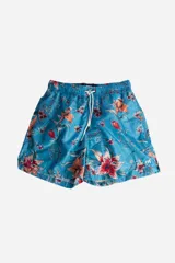 Short de baño de secado rápido con estampado floral sobre fondo azul. Cuenta con cintura elástica con cordón ajustable, bolsillos laterales y logo aplicado en goma.