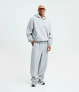 Pantalón baggy gris de algodón con felpa, cintura elástica con cordón ajustable, bolsillos laterales y bajo con regulador elástico.