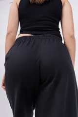 Pantalón de jogging de corte recto y tiro alto, color beige, con cintura elástica y logo bordado pequeño en la parte superior.