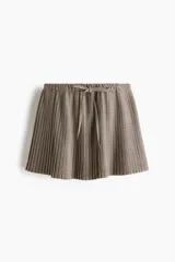 Pollera mini acampanada de tejido plisado con diseño a cuadros, cintura elástica y cordón ajustable.