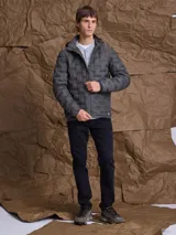 Campera de nylon termosellada con capucha, color azul marino, con cierre frontal y detalles en color naranja en el borde del cierre y costuras de la capucha.