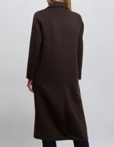 Tapado largo color marrón con cuello de solapa y cierre frontal cruzado con botones. Cuenta con bolsillos laterales con solapa y un relleno interno liviano que proporciona abrigo y estructura.