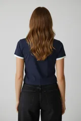 Remera de algodón con elastano, de corte holgado y manga corta. Presenta un diseño tipo ringer con cuello y bordes de mangas en color blanco contrastante sobre una base azul marino. Incluye un estampado gráfico frontal con el número 1991 y detalles de estilo deportivo.