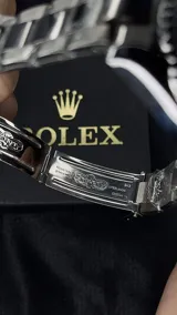 Reloj Rolex Submariner "Batman" con bisel giratorio unidireccional negro y azul, esfera negra con índices luminiscentes, lupa sobre la ventana de fecha y malla de acero inoxidable.