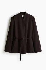 Blazer color marrón oscuro con cuello elevado, hombreras, abertura en los puños y bolsillos delanteros ribeteados. Incluye un cinturón fino con hebilla metálica para ajustar la cintura.