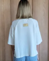 Buzo de punto color verde kiwi con cuello, puños y ruedo en azul.