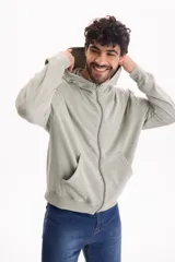 Campera con capucha y cierre frontal, color beige con efecto lavado stone wash, bolsillos tipo canguro y corte oversize.