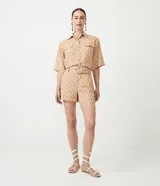 Short color beige con estampado de lunares blancos, tiro medio, trabillas en la cintura y cinturón forrado con hebilla.